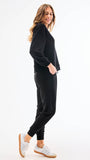 Woman wearing a black outfit with white sneakers on a white background