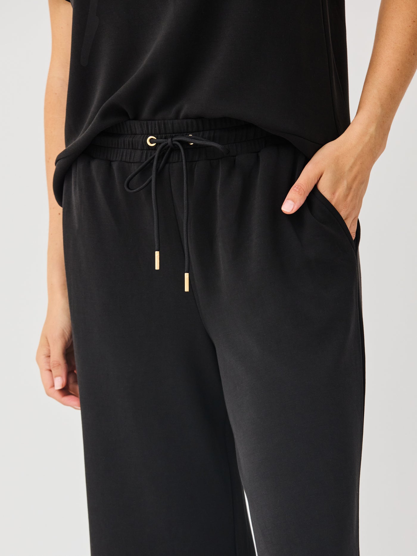 Black pants with drawstring waist on a light gray background