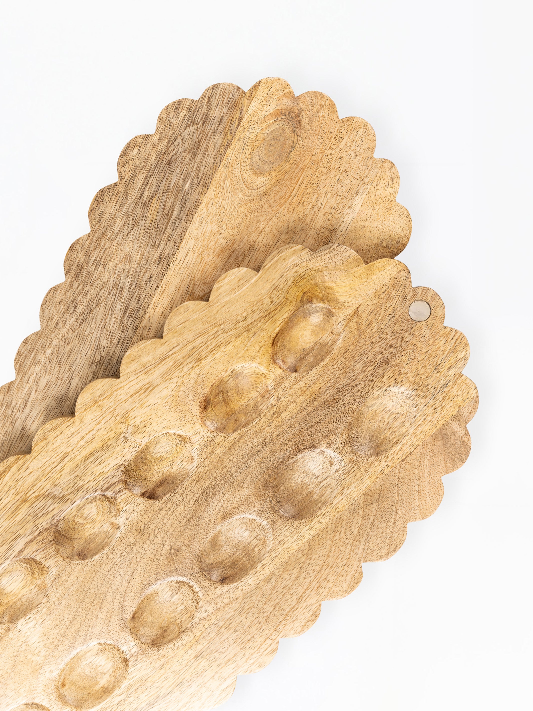 Three scalloped-edge wooden serving boards with raised oval indentations, shown overlapping on a plain white background.
