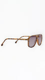 Sunglasses with tortoiseshell frame and dark lenses on a white background
