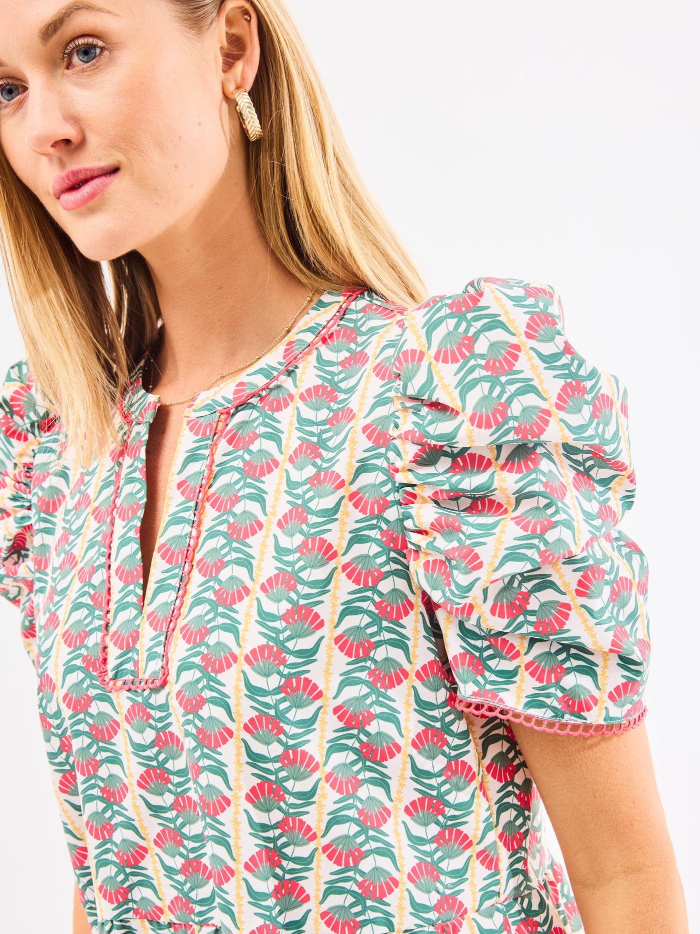 Woman in a floral dress with white background.