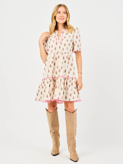 Woman wearing a floral dress featuring puff sleeves, pink trim on a white background