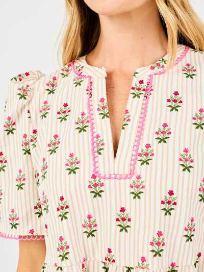 Close-up of a woman wearing a floral patterned dress with pink trim.
