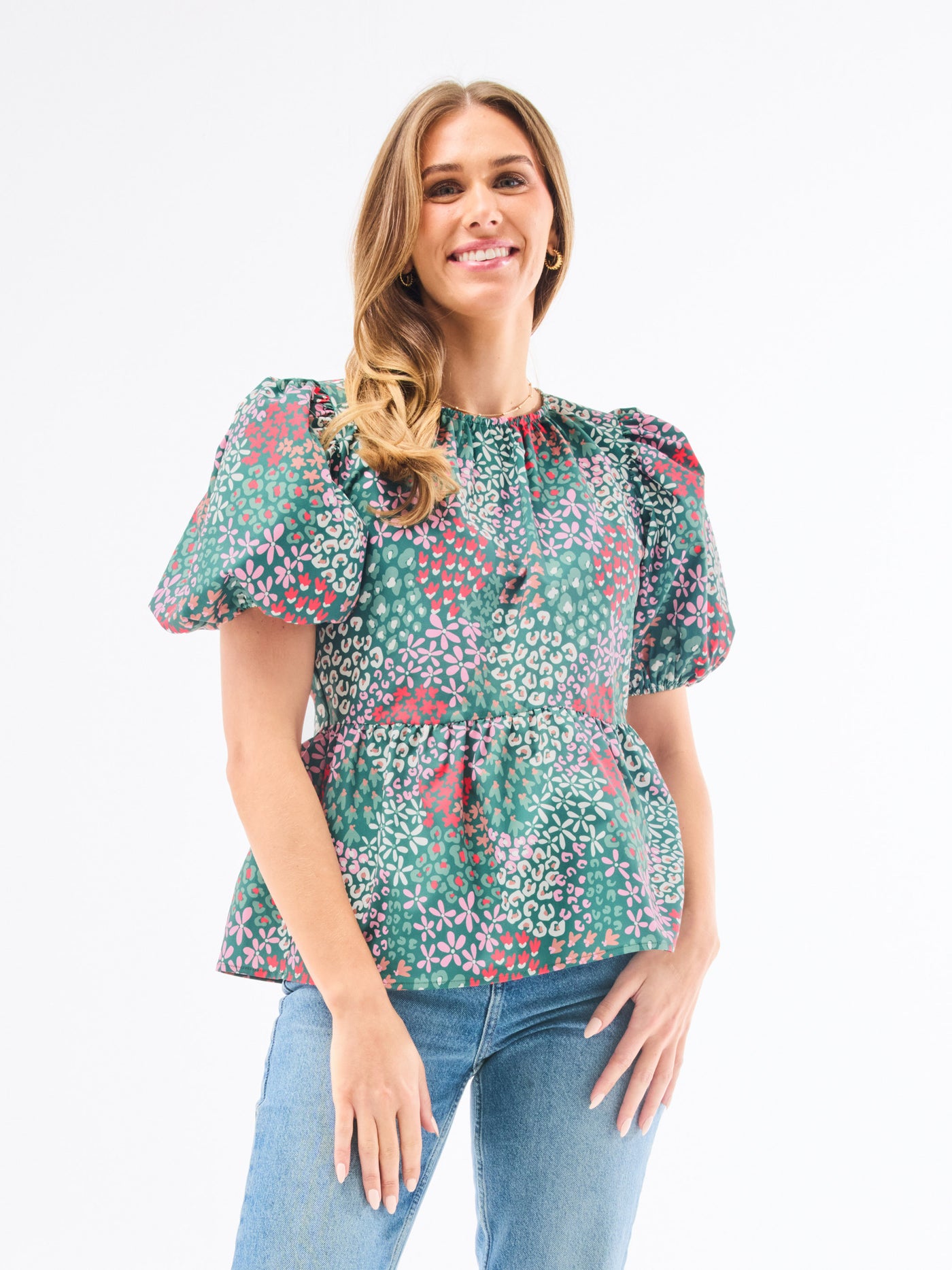 Woman wearing a floral blouse and jeans on a white background