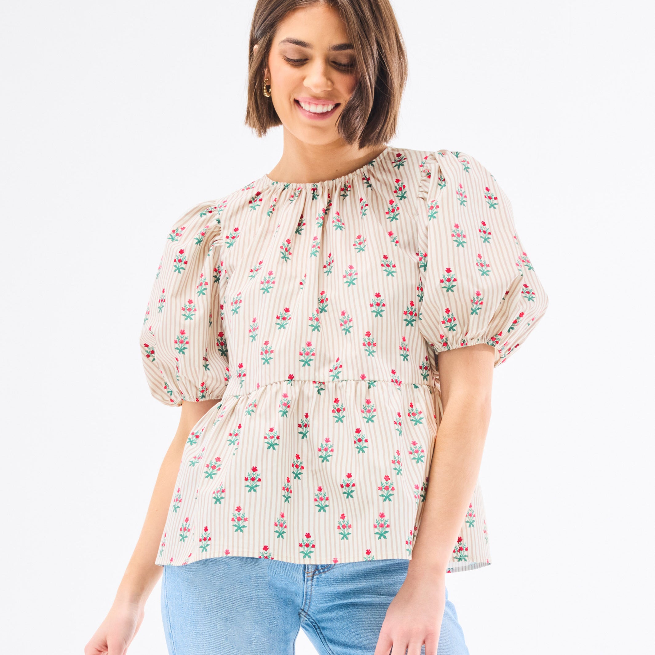 Woman wearing a floral blouse with puffed sleeves on a white background