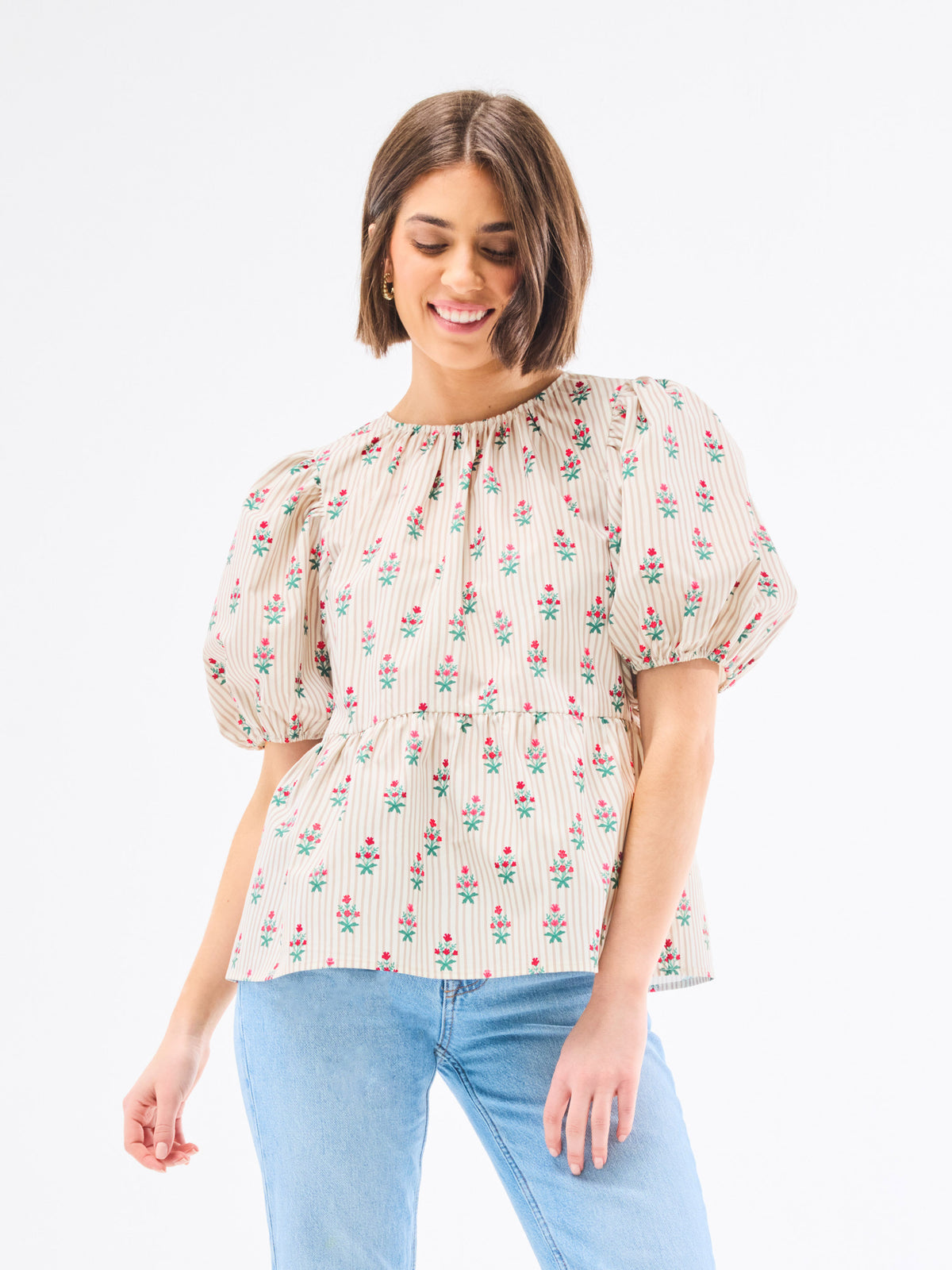 Woman wearing a floral blouse with puffed sleeves on a white background