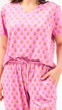Woman wearing a floral pajama set on a white background