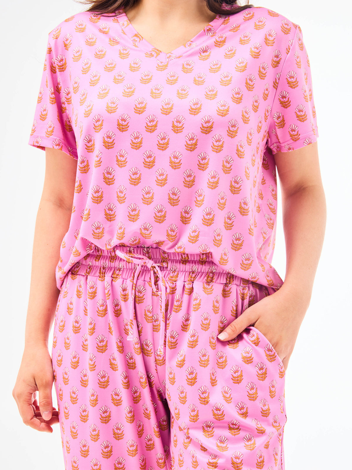 Woman wearing a floral pajama set on a white background