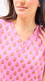 Close-up of a pink top with a subtle pattern worn by a person.