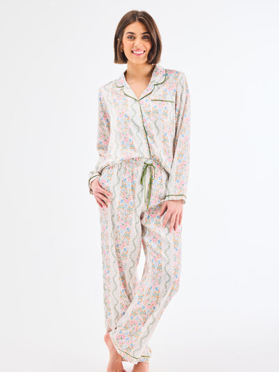 Woman wearing a floral pajama set on a white background