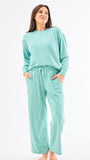 Woman wearing a teal loungewear set on a white background