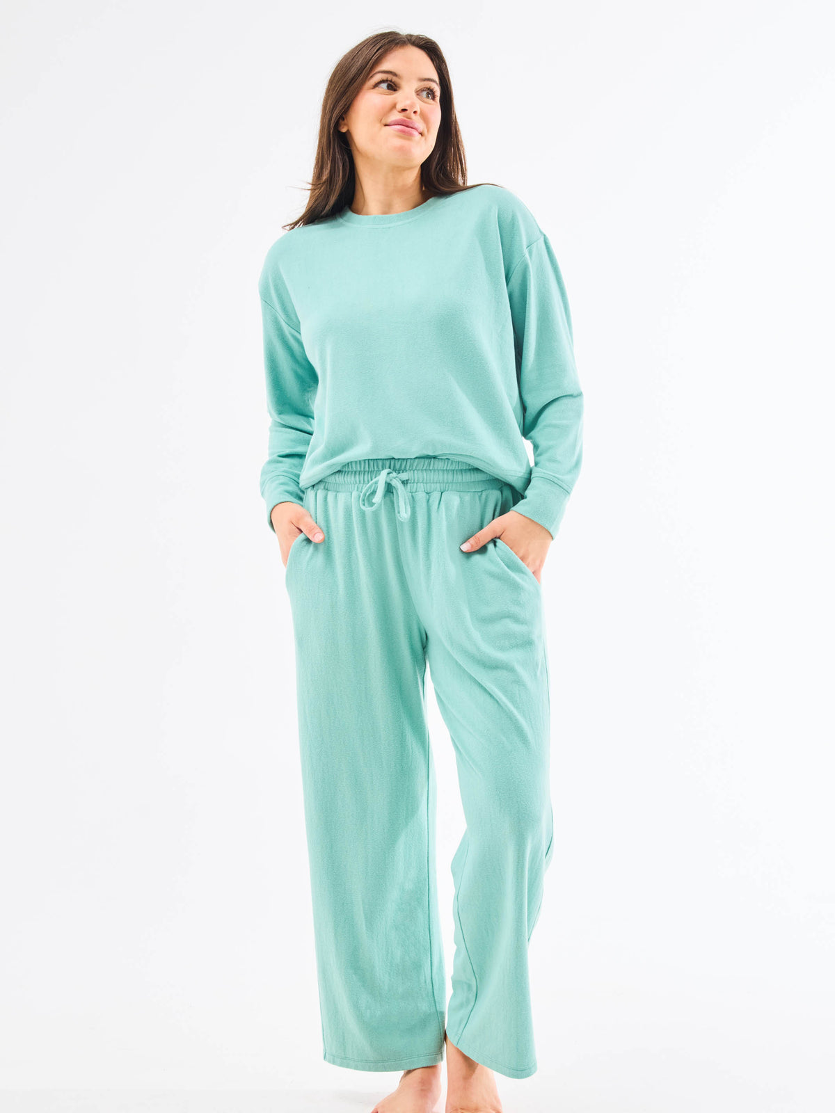 Woman wearing a teal loungewear set on a white background