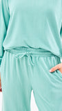 Teal loungewear set with a matching top and pants on a white background