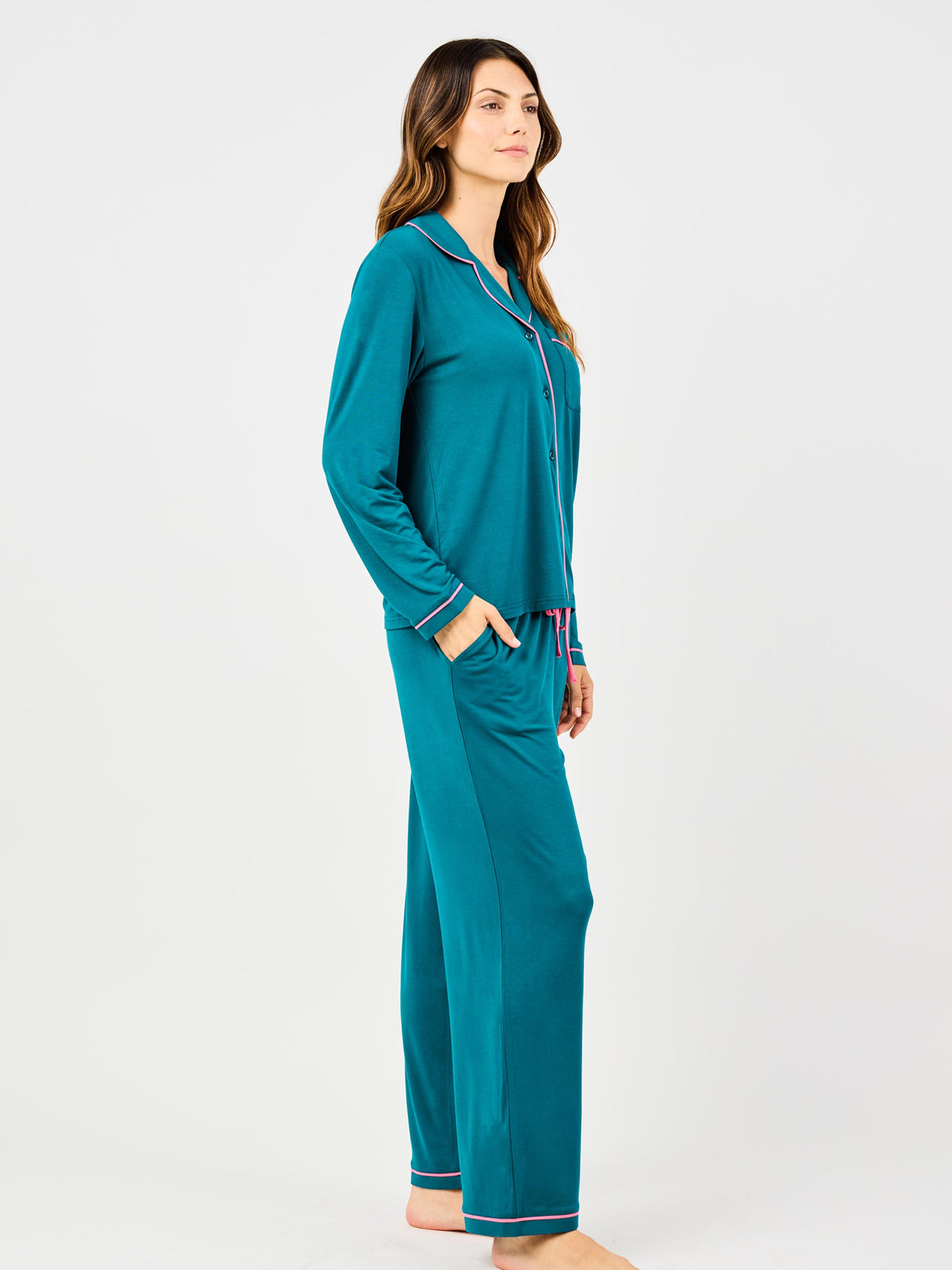 Woman wearing teal pajama set on a white background