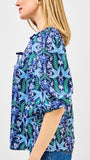 Woman wearing a blue floral patterned shirt on a white background