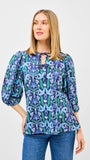 Woman wearing a blue floral blouse with a white background
