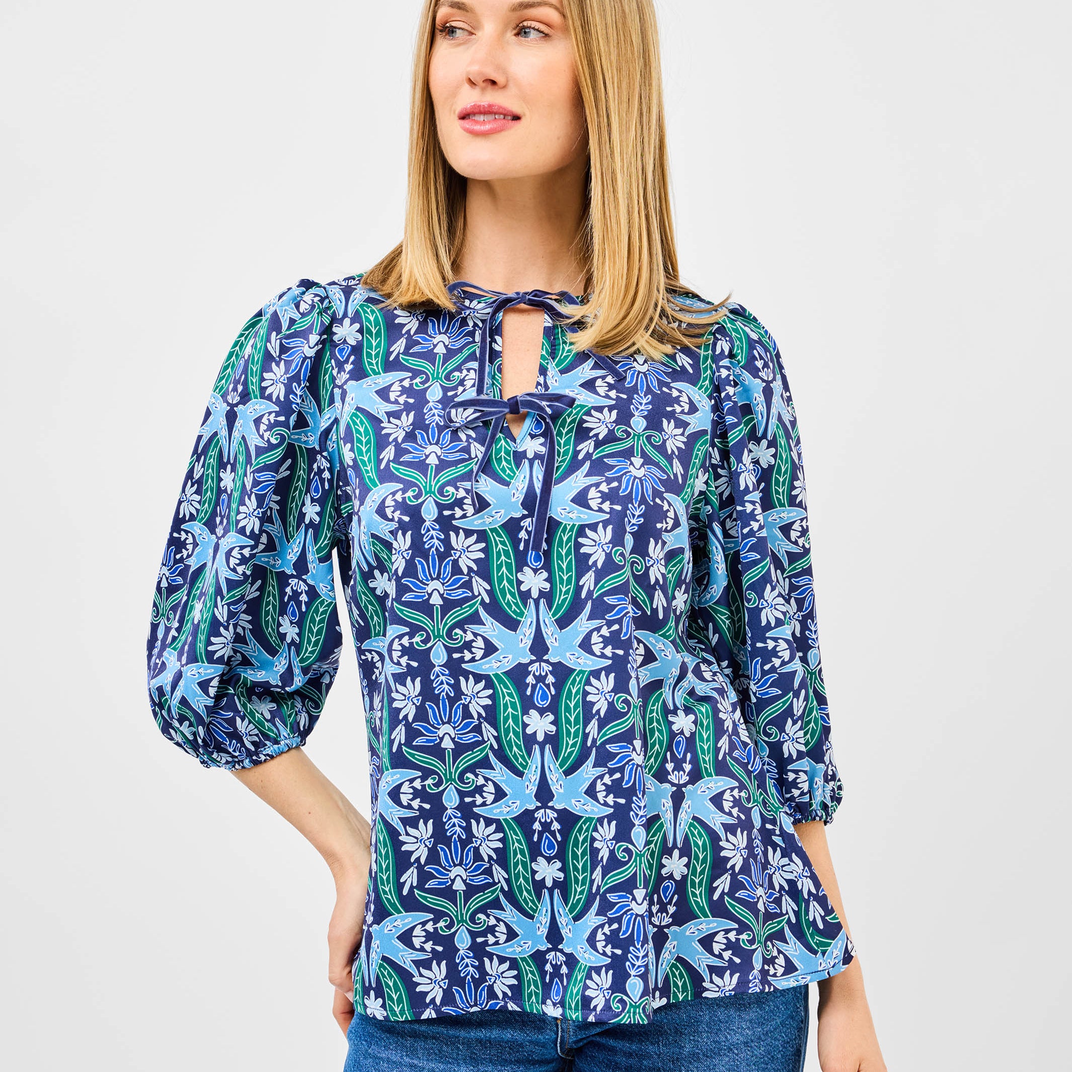 Woman wearing a blue floral blouse with a white background