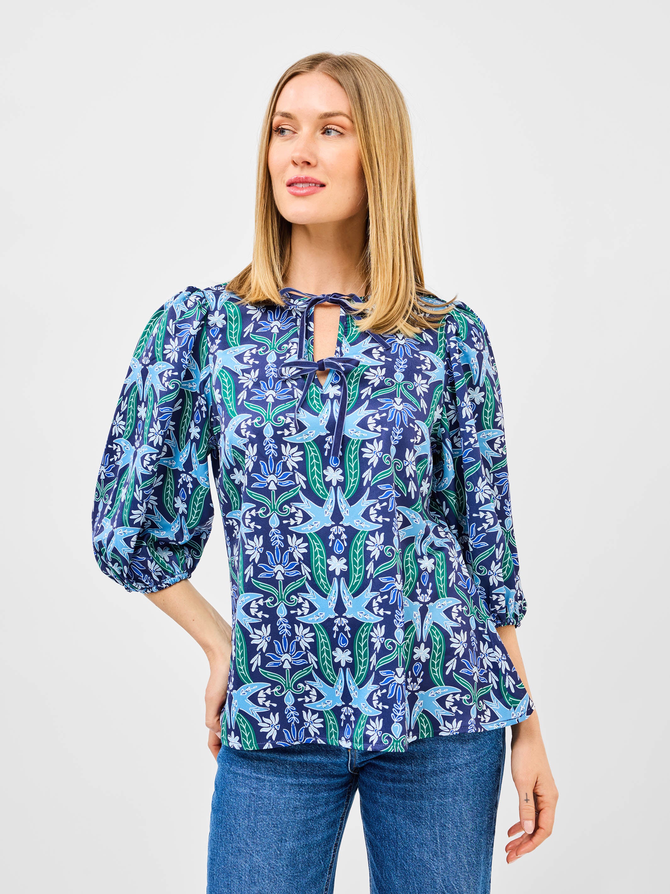 Woman wearing a blue floral blouse with a white background