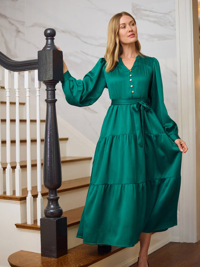 Woman in a green dress standing on a staircase