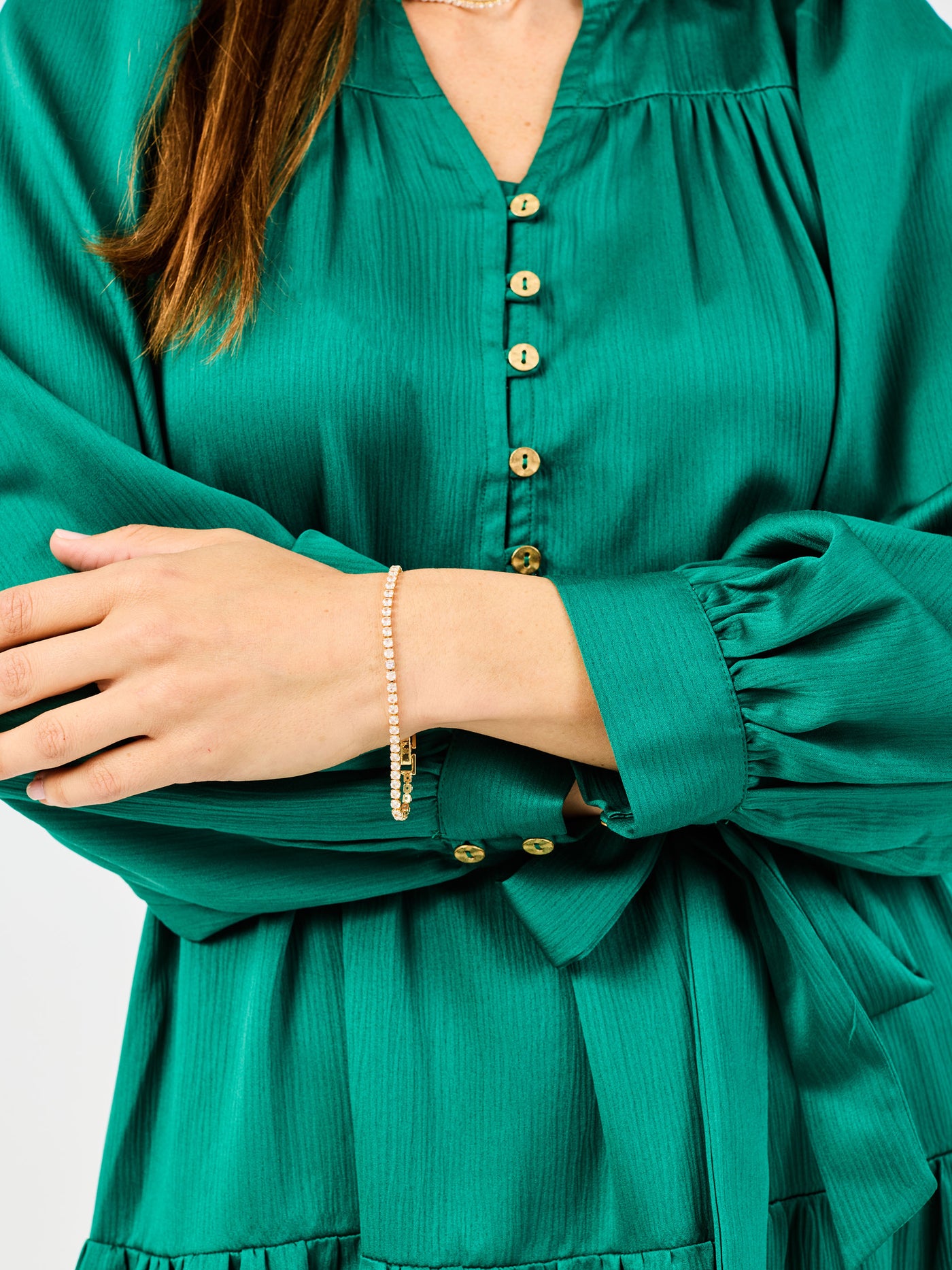 Green dress with gold buttons worn by a person, on a white background