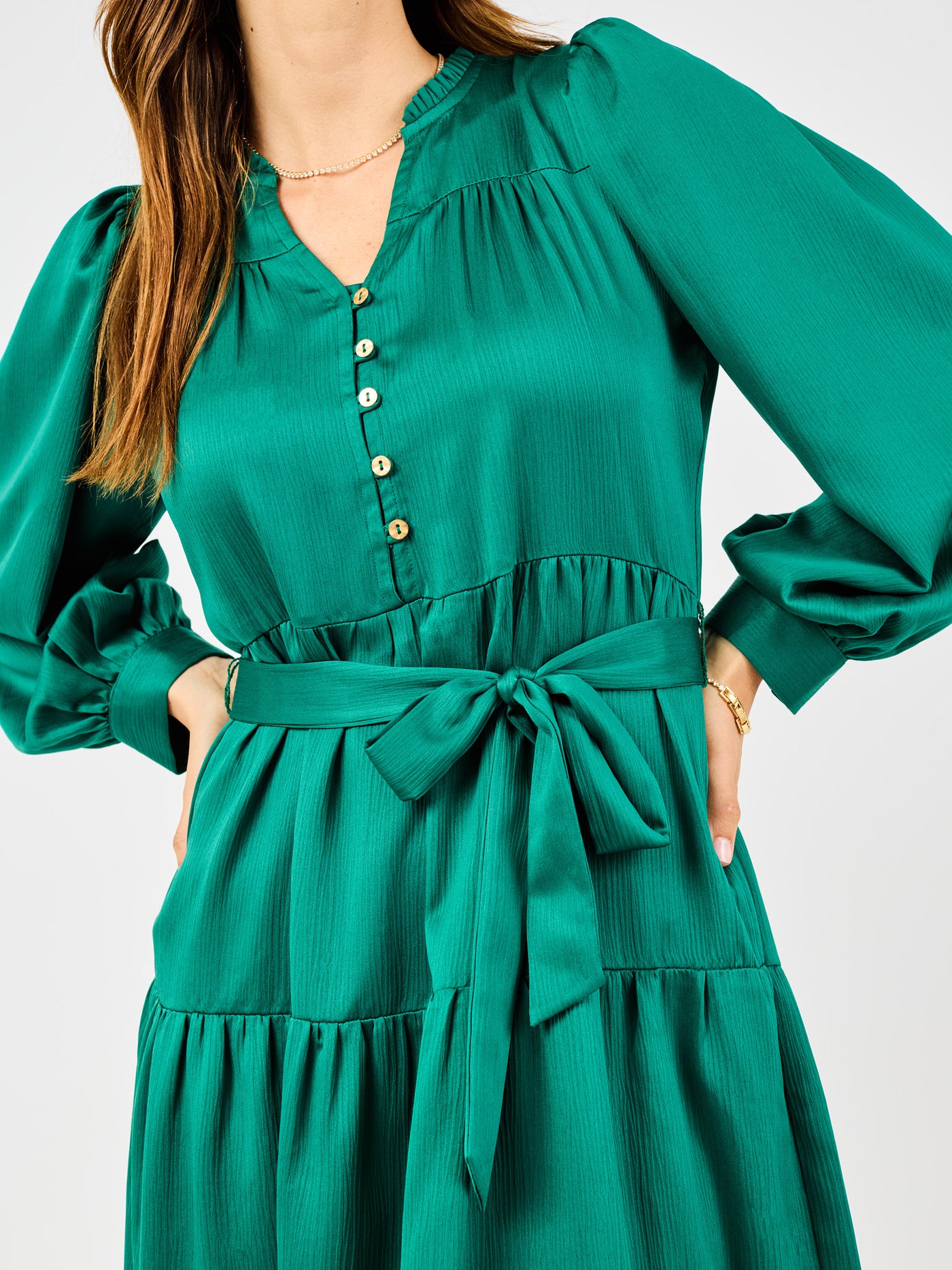 Green dress with long sleeves and a tie waist on a white background