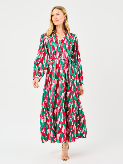 Woman wearing a colorful patterned holiday dress with pinks, greens, reds and whites on a white background