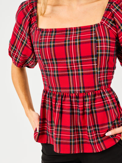 Red plaid top with puff sleeves on a plain background