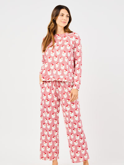 Woman wearing a red santa and striped patterned pajama set on a white background