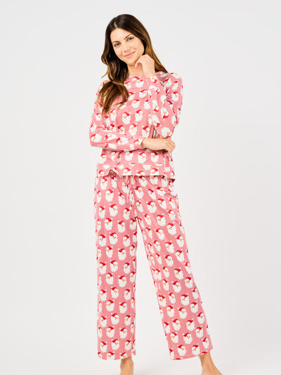 Woman wearing a red santa claus and striped patterned pajama set on a white background