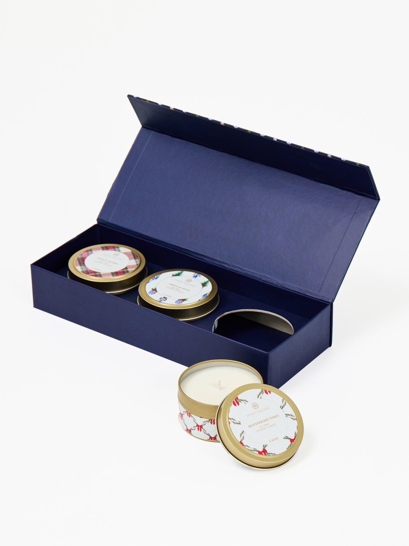 Set of 3 candles in decorative tins with a blue gift box on a white background
