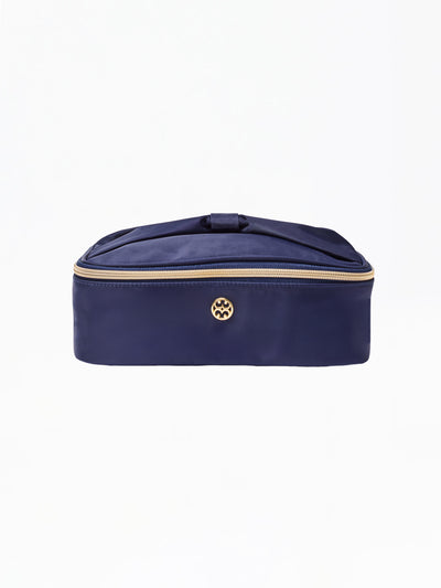 Navy blue cosmetic bag with gold zipper and logo on a white background