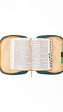 Open bible inside a teal and beige bible cover on a white background