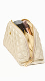 Gold makeup pouch with cosmetic items on a white background