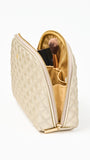 Quilted champagne colored cosmetic bag on a white background