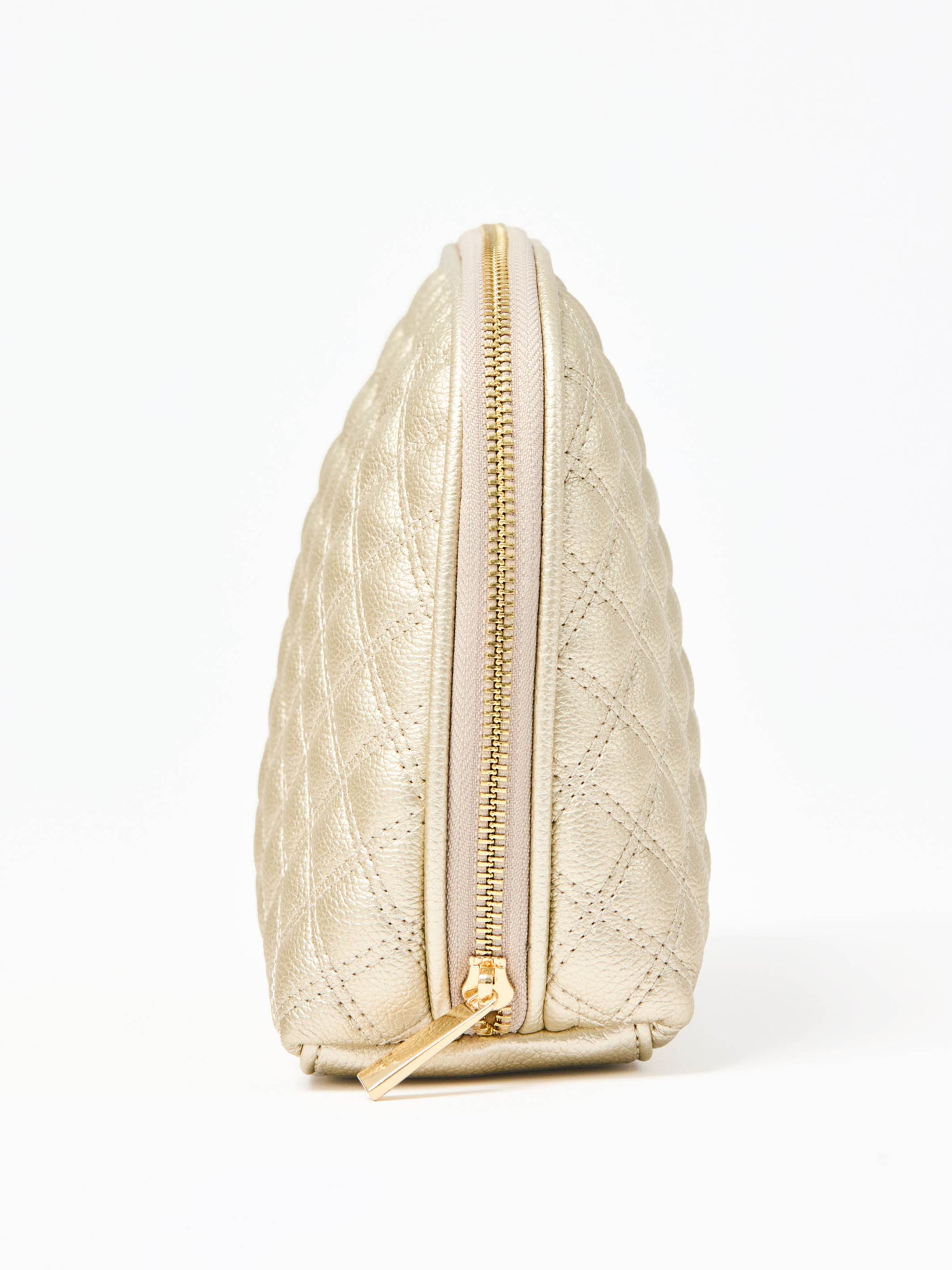 Quilted champagne colored cosmetic bag on a white background