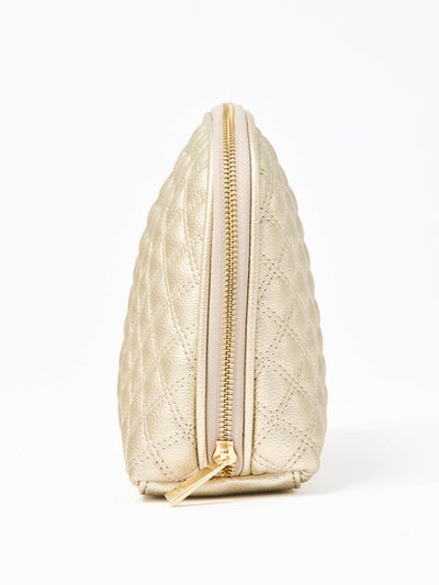 Quilted champagne colored cosmetic bag on a white background
