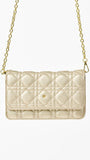 Champagne colored quilted handbag with gold chain strap on a white background