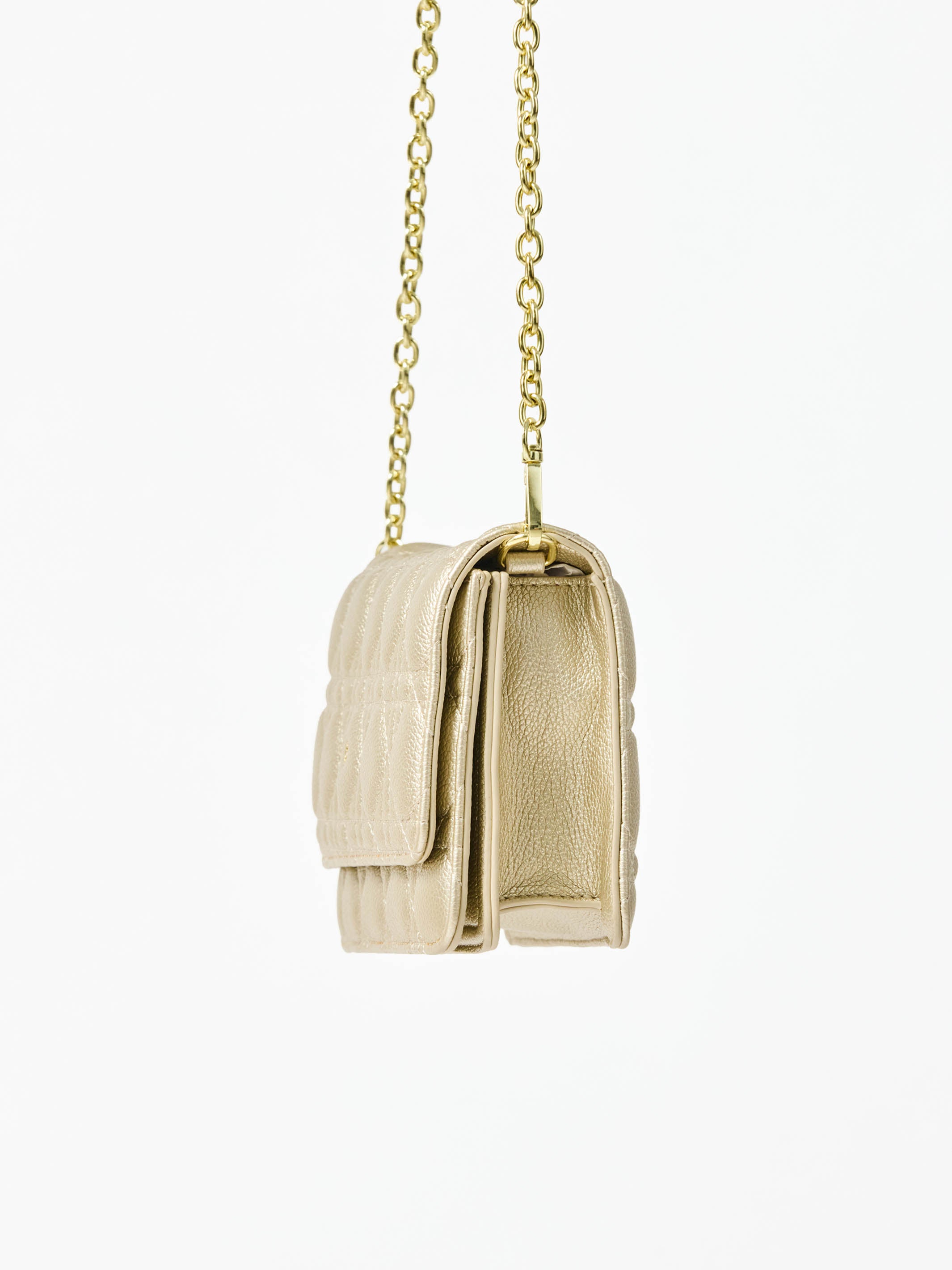 Champagne colored quilted handbag with gold chain strap on a white background