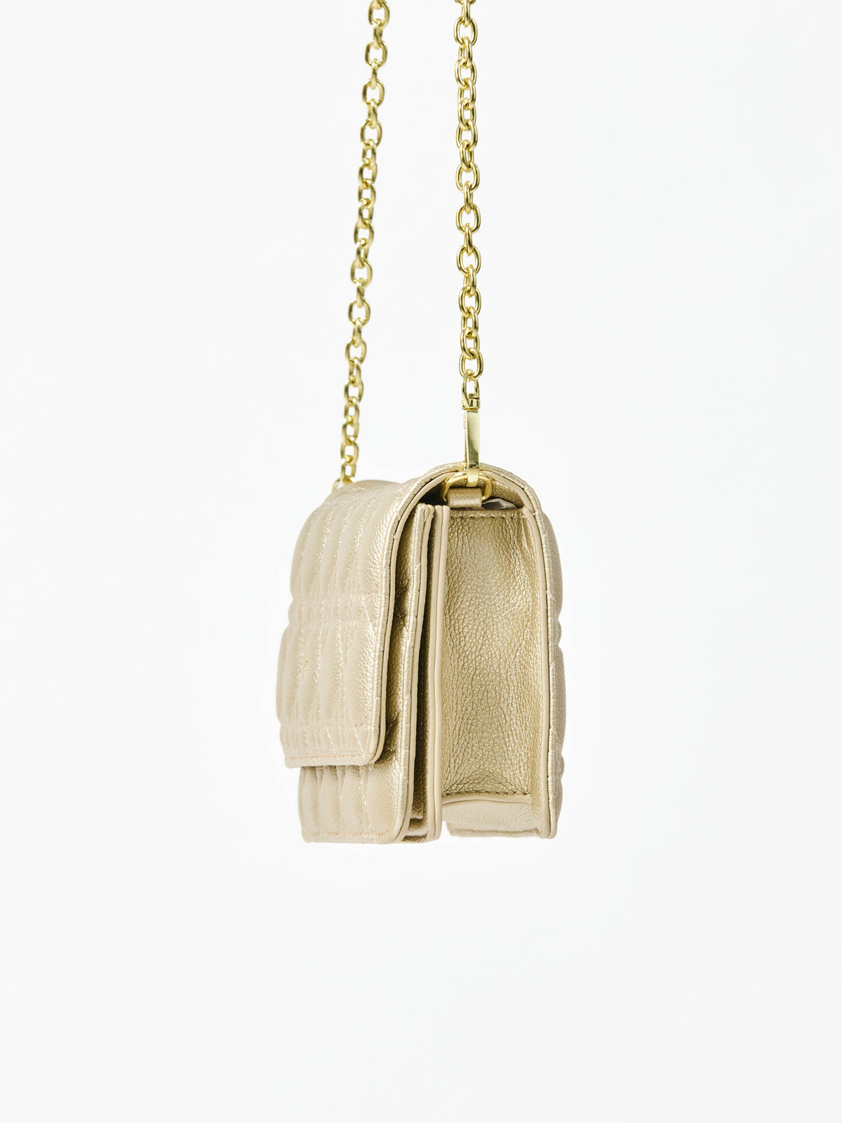Champagne colored quilted handbag with gold chain strap on a white background