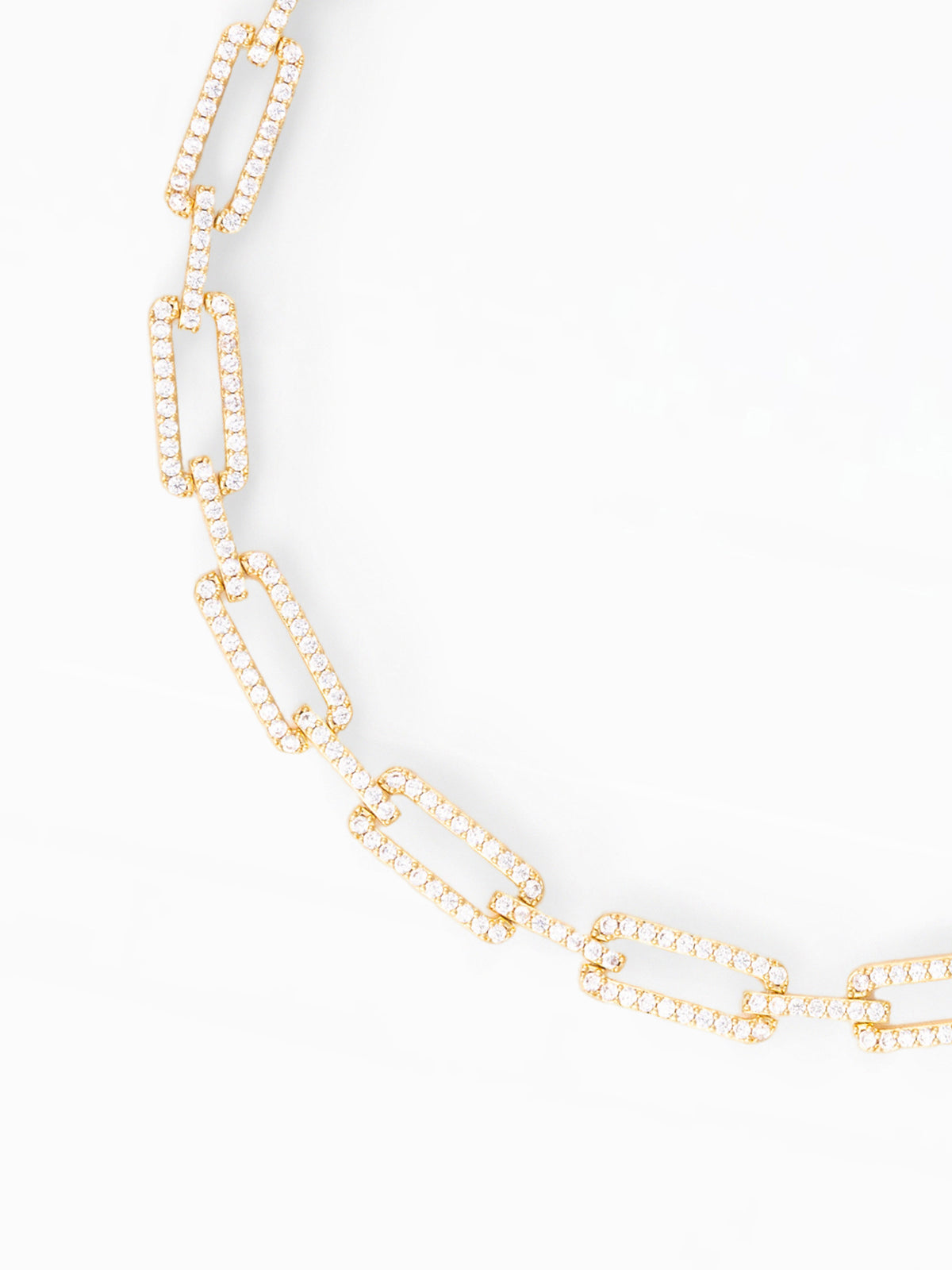 A gold-tone chain necklace with elongated rectangular links paved with small clear stones, photographed on a clean white background.