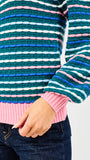 Colorful striped sweater with a pink hem and blue sleeves on a white background