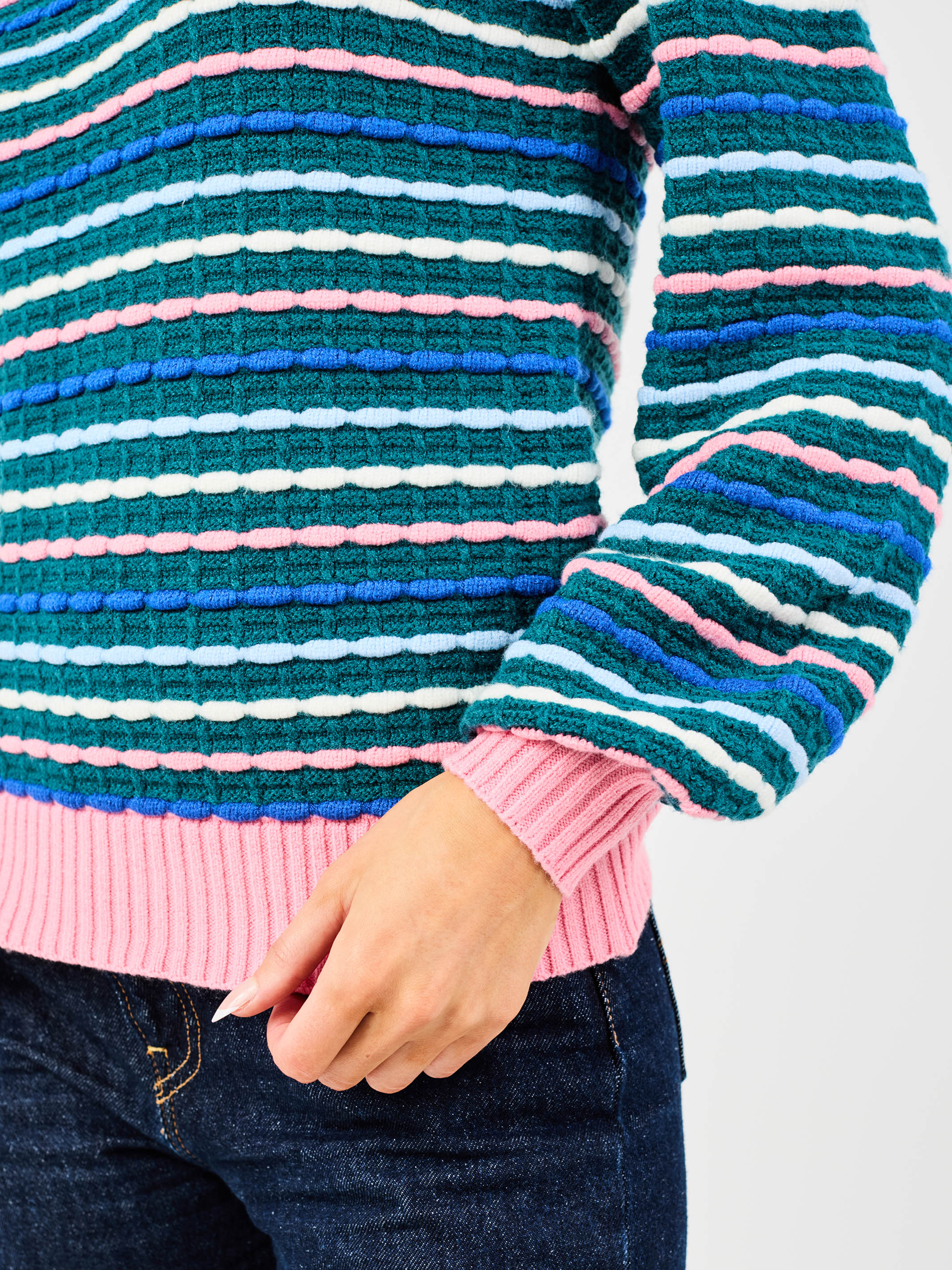 Colorful striped sweater with a pink hem and blue sleeves on a white background