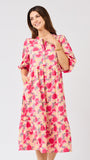Woman wearing a  pink floral midi dress on a white background