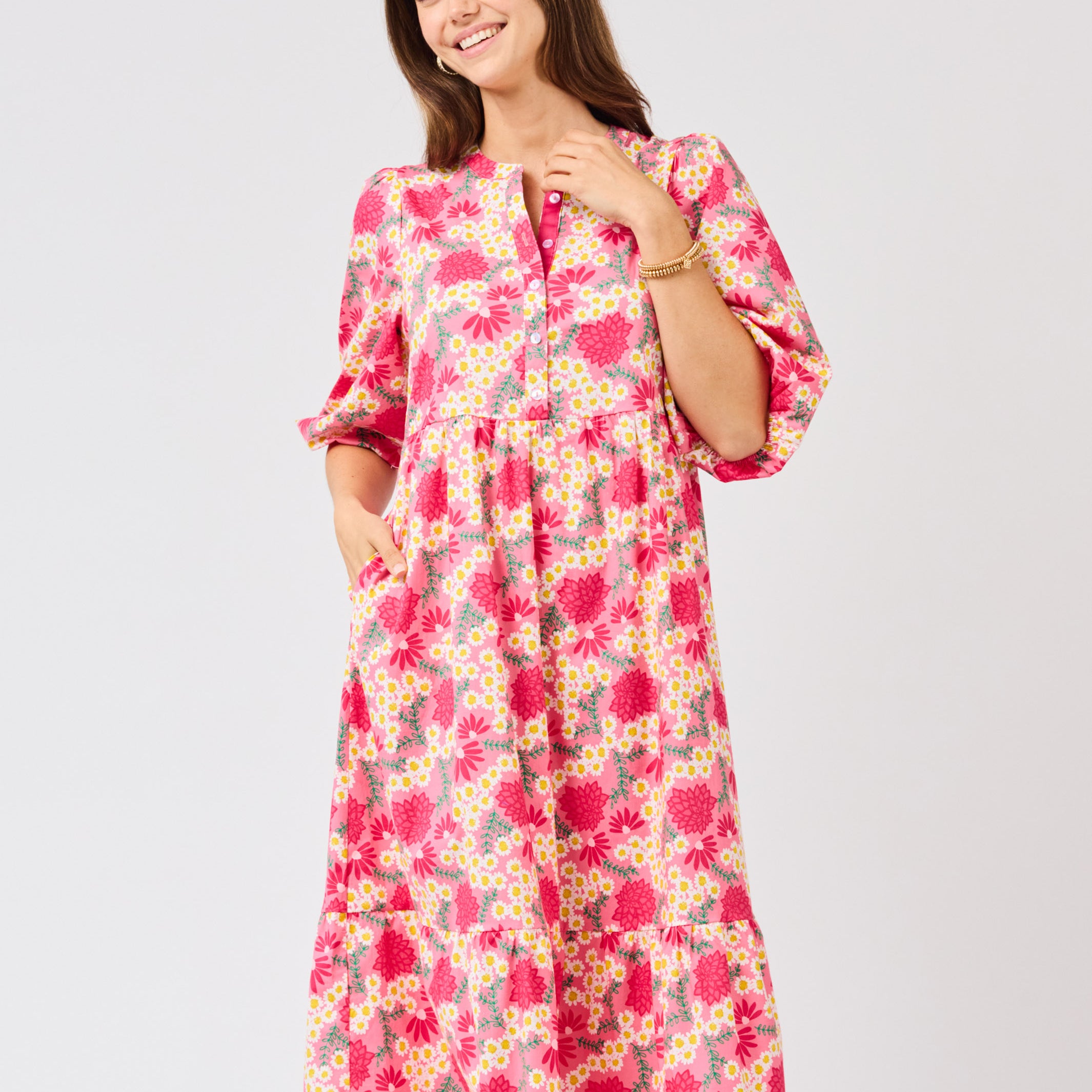 Woman wearing a  pink floral midi dress on a white background