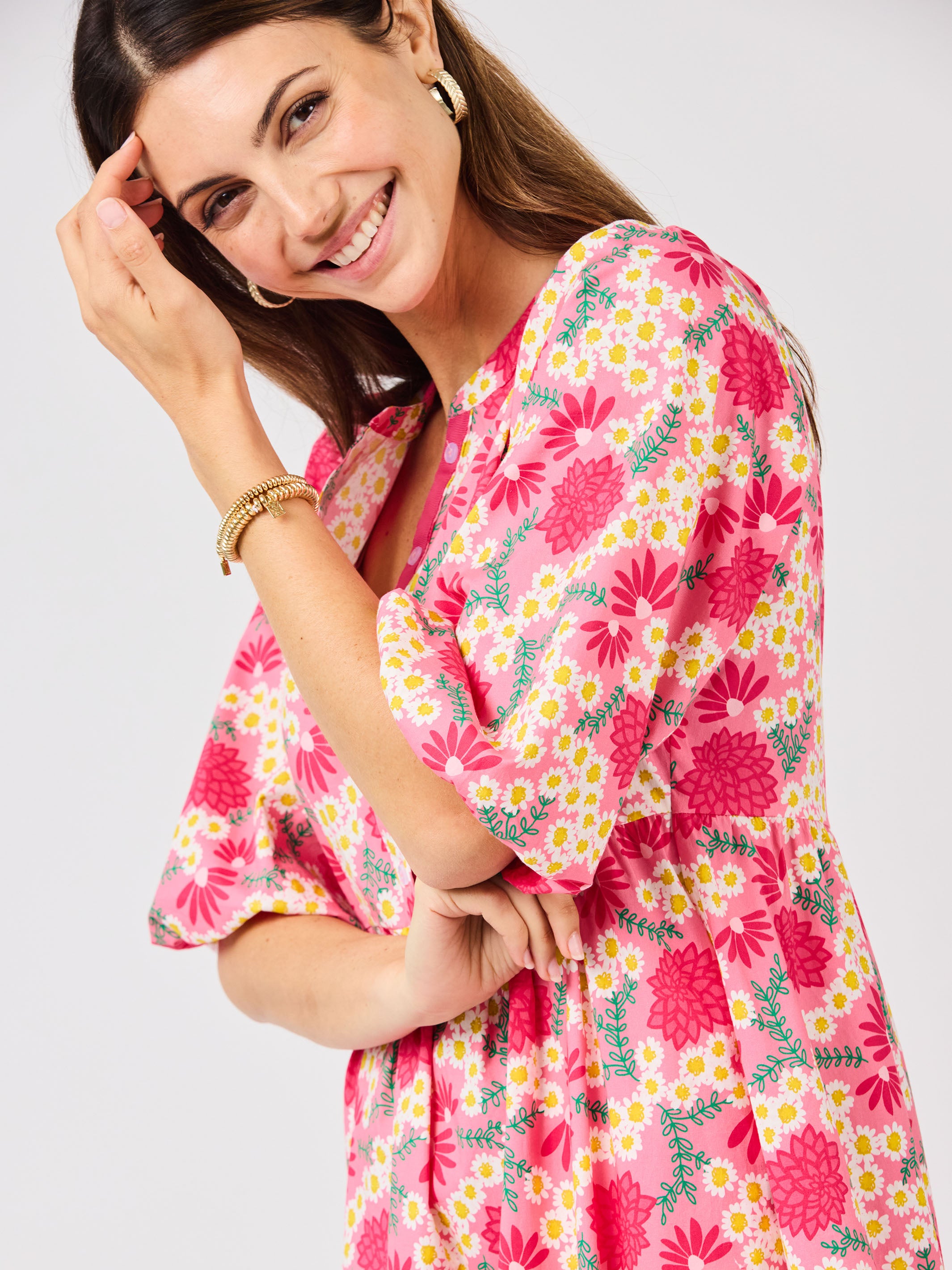 Woman wearing a  pink floral midi dress on a white background