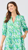 Woman wearing a green floral dress on a light gray background
