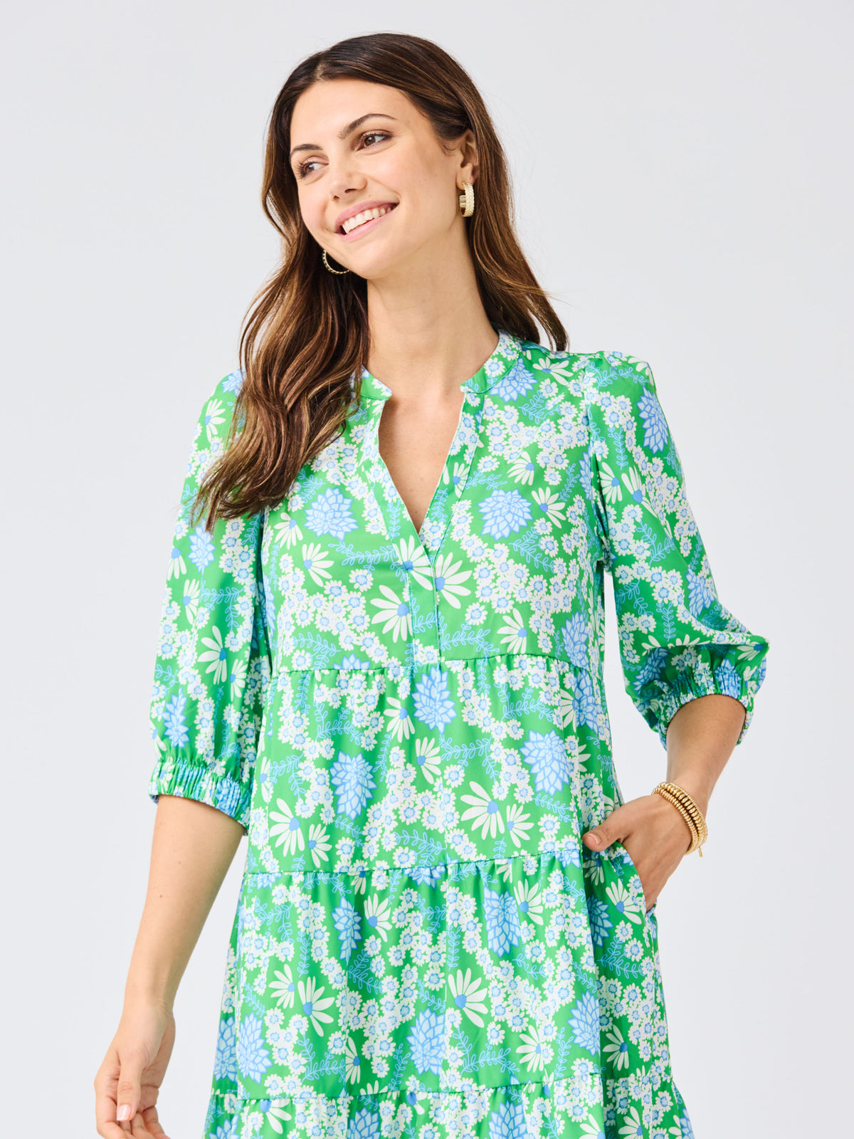 Woman wearing a green floral dress on a light gray background