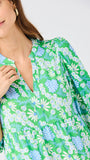 Woman wearing a green floral dress against a white background
