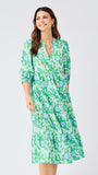 Woman wearing a green floral dress on a white background
