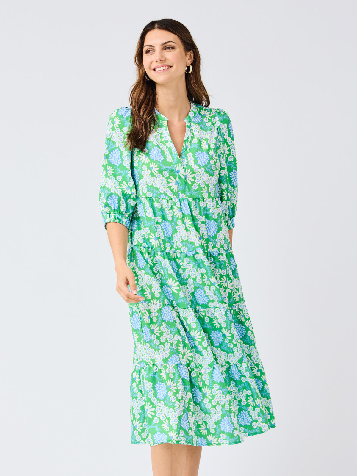Woman wearing a green floral dress on a white background